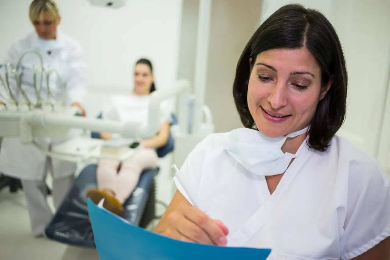 Dentista fazendo papel de recepcionista, situação típica de quem precisa saber como registrar um funcionário